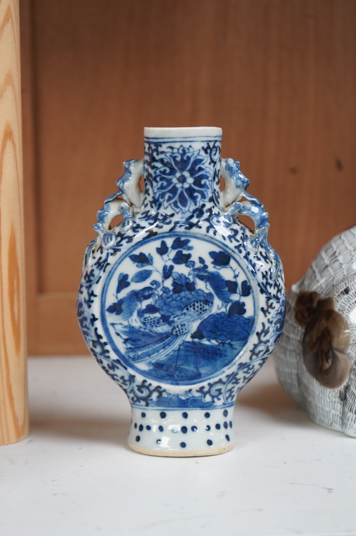 A 19th century Chinese blue and white small moon flask together with a later jar and a Portugese porcelain copy of a Chinese export cat, largest 19cm high